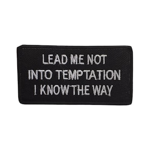 May include: Black embroidered patch with white text that reads "Lead me not into temptation I know the way".