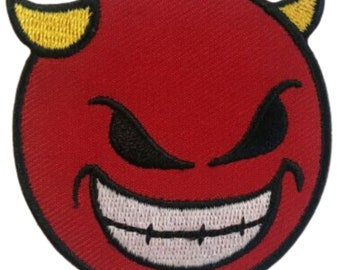 Puede incluir: Emoji de diablo rojo con cuernos amarillos y una sonrisa blanca y dentada. El emoji tiene ojos negros con una expresión traviesa.