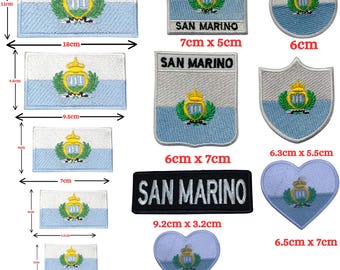 Könnte beinhalten: Eine Sammlung bestickter Aufnäher mit der Flagge von San Marino in verschiedenen Formen und Größen, darunter rechteckige, runde, schildförmige und herzförmige Designs. Einige Aufnäher zeigen den Text SAN MARINO in schwarzer oder weißer Stickerei.
