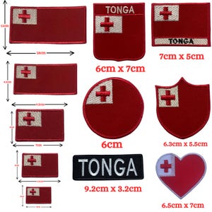 May include: A collection of embroidered patches featuring the red and white flag of Tonga in various shapes and sizes, including rectangular, circular, shield, and heart designs. Some patches include the text TONGA in white or black lettering.