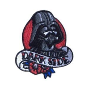 Puede incluir: Un parche bordado con Darth Vader de Star Wars. El parche es negro, gris y rojo con una pancarta blanca que dice "Dark Side".