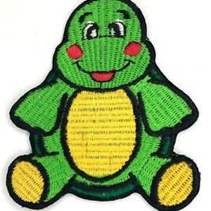 Op de afbeelding: Groene geborduurde strijk-op-patch van een glimlachende cartoon-schildpad met gele voeten en schild.
