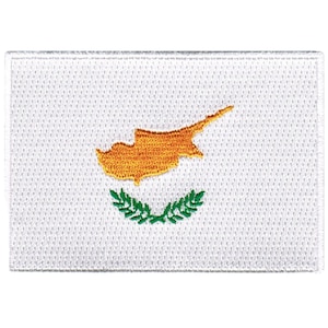 May include: A white embroidered patch with the flag of Cyprus. The flag features a yellow outline of the island of Cyprus and a green olive branch wreath.
