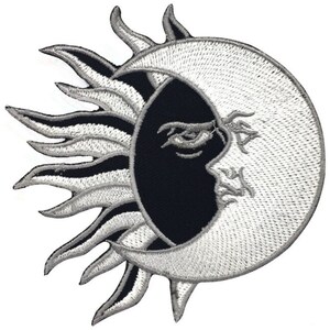 May include: A black and white embroidered patch featuring a sun and moon design. The sun has a stylised, flame-like design and the moon is crescent shaped with a face.