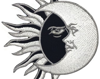 May include: A black and white embroidered patch featuring a sun and moon design. The sun has a stylised, flame-like design and the moon is crescent shaped with a face.