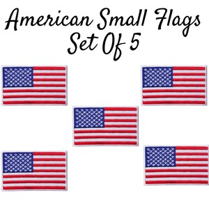 Peut inclure: Ensemble de cinq petits drapeaux américains. Chaque drapeau est brodé de rayures rouges et blanches et d'étoiles bleues sur un fond blanc. Les drapeaux sont entourés d'une bordure blanche.