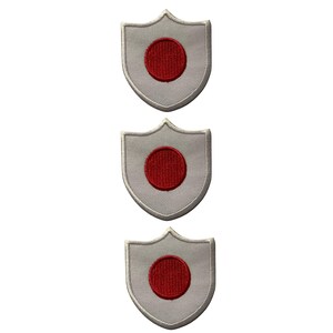 May include: Three shield-shaped patches displaying the Japanese flag. Each patch has a grey background with a red circle in the centre, representing the sun. The patches are embroidered with a white border.
