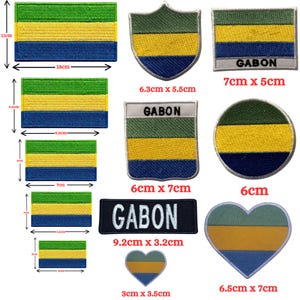 May include: A collection of embroidered patches featuring the green, yellow, and blue horizontal stripes of the Gabon flag in various shapes including rectangles, shields, circles, and hearts, with some patches displaying the text GABON.