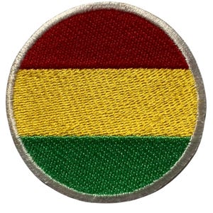 May include: A round embroidered patch with the colors of the Bolivian flag. The patch is red, yellow, and green.