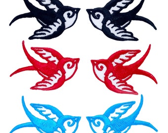 May include: Set of six embroidered iron-on patches featuring a classic swallow design. The patches are available in black, red, and blue.
