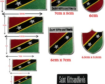 Könnte beinhalten: Eine Sammlung bestickter Aufnäher mit der Flagge von St. Kitts und Nevis in verschiedenen Formen und Größen. Rechteckige, runde und schildförmige Aufnäher zeigen das grün-schwarz-rot-gelbe Flaggendesign mit zwei weißen Sternen. Einige enthalten den Text Saint Kitts and Nevis mit Abmessungen von 3cm bis 18cm.