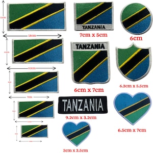 May include: A selection of Tanzania flag patches in different shapes and sizes. The patches display the flag's green, black, yellow, and blue colours. Some patches have the word "TANZANIA" embroidered in white.