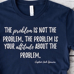 May include: Navy blue t-shirt with white text that reads "THE problem IS NOT THE PROBLEM. THE PROBLEM IS YOUR attitude ABOUT THE PROBLEM. -Captain Jack Sparrow"