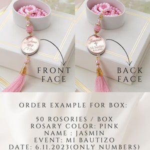 May include: A pink rosary with a gold charm that says "Jesus Loves Me" on the front and "Jasmin Mi Bautizo 6.11.2023" on the back. The rosary is in a white box with a pink tassel.