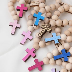 May include: Wooden bead rosaries with colorful painted crosses in shades of pink, blue, and gold. Each rosary features a wooden tag with the text "Sofia's Baptism" and the date "February 2023".