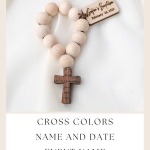 May include: A wooden rosary with light-colored beads and a dark wooden cross. A small wooden tag is attached, inscribed with "Sofia's Baptism" and the date "February 26, 2023". The image includes text that says "Personalize", "Cross Colors", "Name and Date", and "Event Name".