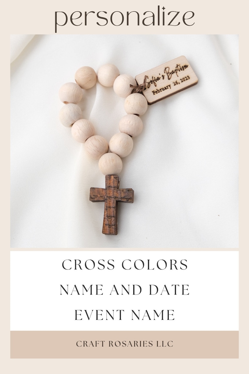 May include: A wooden rosary with light-colored beads and a dark wooden cross. A small wooden tag is attached, inscribed with "Sofia's Baptism" and the date "February 26, 2023". The image includes text that says "Personalize", "Cross Colors", "Name and Date", and "Event Name".