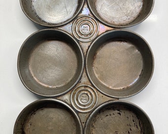 A pair ofVintage/Old early circular low biscuit/muffin tins, patent pending written in circles, used but decorative condition.