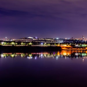 Night city. Big city lights and lake. Glowing houses. River through the city. Night sky and shining lake. Town at night. City wall art photo