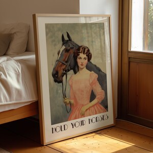 Vintage-style poster of a woman in a pink dress standing beside a horse, styled as equestrian wall art with country chic art and western decor charm, text reads “HOLD YOUR HORSES”