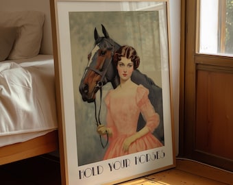 May include: A framed wall art print featuring a person in a peach-colored dress standing next to a brown horse with a black bridle. The text "HOLD YOUR HORSES" is printed in black capital letters at the bottom of the rectangular poster.