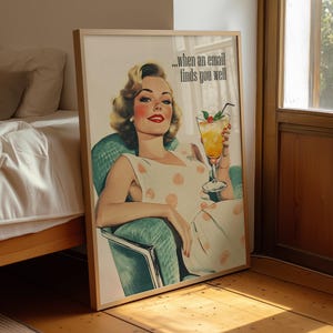 Op de afbeelding: Een ingelijste vintage print met een vrouw in een polkadotjurk die een cocktail vasthoudt. De print bevat de tekst "...when an email finds you well". De vrouw zit in een turquoise stoel, met een slaapkamer en een raam op de achtergrond.
