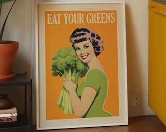 May include: A framed rectangular wall art print featuring a retro-style illustration of a person with dark hair wearing a green top, holding a large bunch of broccoli against an orange background with the text EAT YOUR GREENS in white letters.