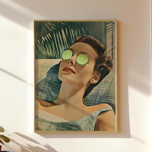 May include: A framed wall art print depicting a person with dark hair resting with green cucumber slices over their eyes. The person wears a light blue plaid top and is positioned against a background of palm leaves and slatted shadows.