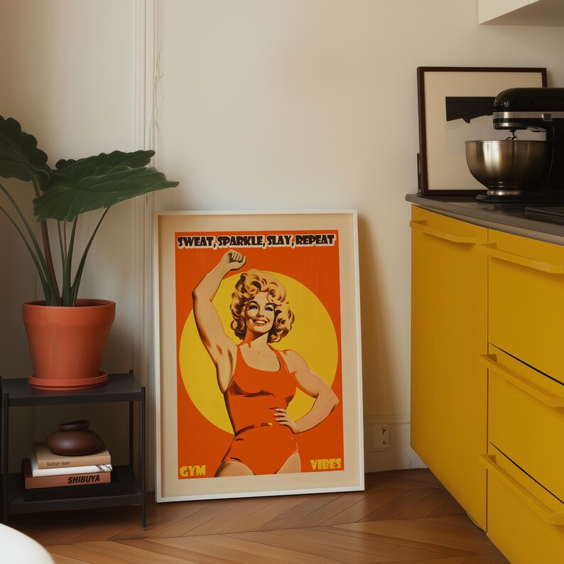 Retro gym art featuring an 80s style woman in an orange bodysuit flexing. Vibrant yellow sun background with the text Sweat Sparkle Slay Repeat. Maximalist dopamine decor for home gym walls.