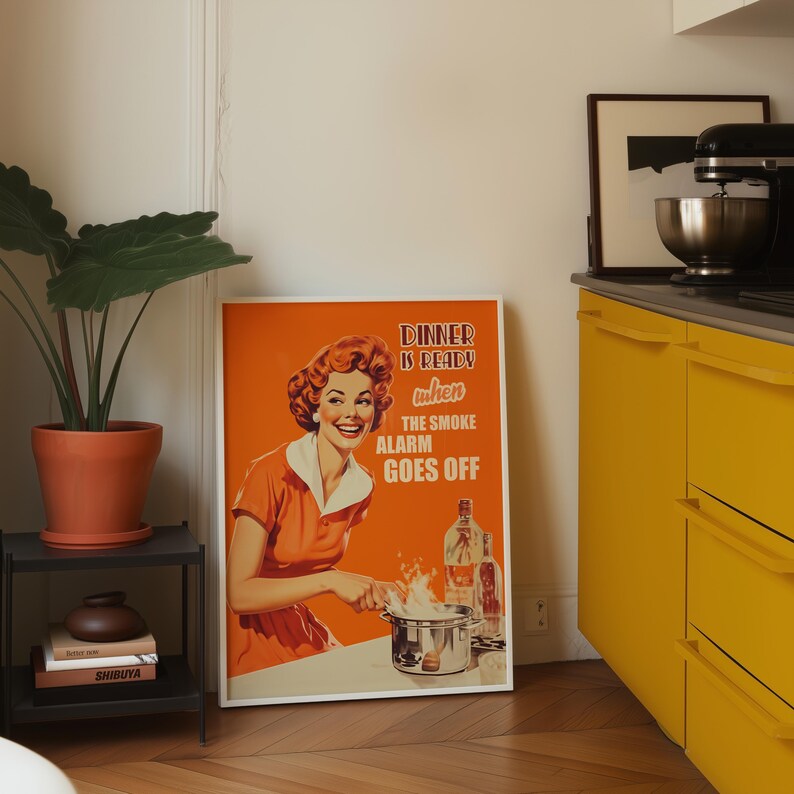 Retro style poster of a smiling housewife in an orange kitchen with a funny quote. Fun kitchen print in a 50s aesthetic for nostalgic decor.
