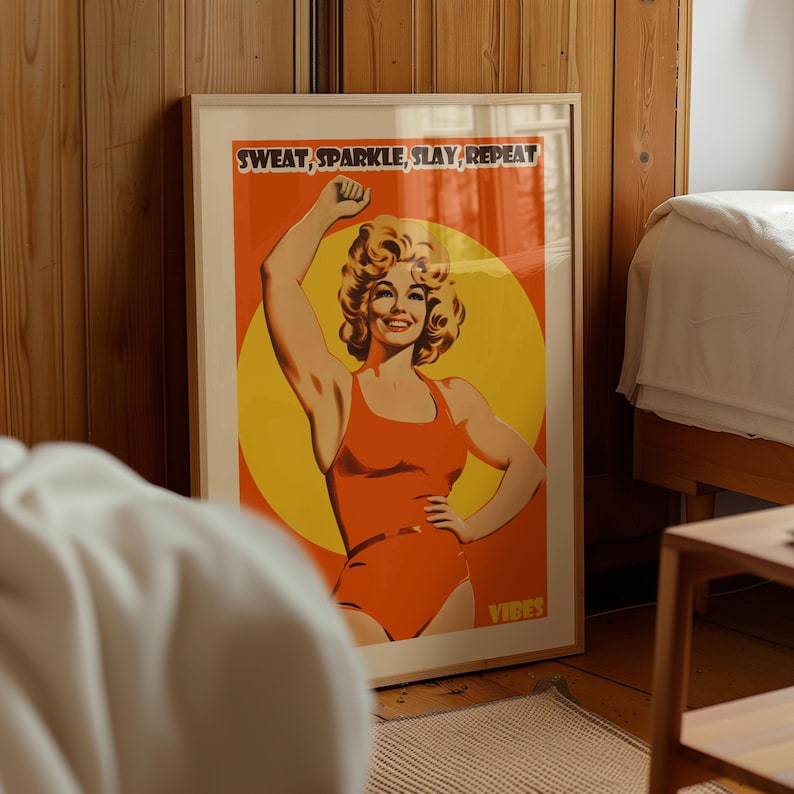 Retro gym art featuring an 80s style woman in an orange bodysuit flexing. Vibrant yellow sun background with the text Sweat Sparkle Slay Repeat. Maximalist dopamine decor for home gym walls.