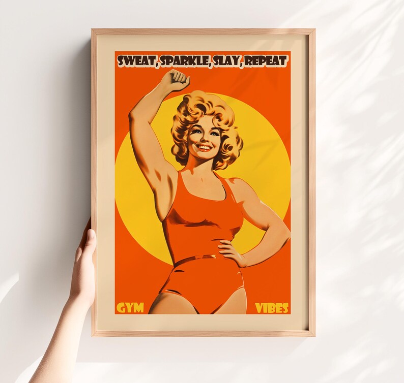 Retro gym art featuring an 80s style woman in an orange bodysuit flexing. Vibrant yellow sun background with the text Sweat Sparkle Slay Repeat. Maximalist dopamine decor for home gym walls.