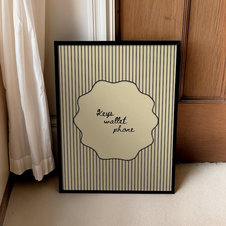 Hand drawn poster with the text "Keys wallet phone" inside a scalloped border on a neutral pinstripe background. Simple modern art used as Functional decor for Apartment decor or an Art for hall.