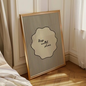 Hand drawn poster with the text "Keys wallet phone" inside a scalloped border on a neutral pinstripe background. Simple modern art used as Functional decor for Apartment decor or an Art for hall.