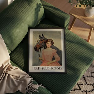 Vintage-style poster of a woman in a pink dress standing beside a horse, styled as equestrian wall art with country chic art and western decor charm, text reads “HOLD YOUR HORSES”