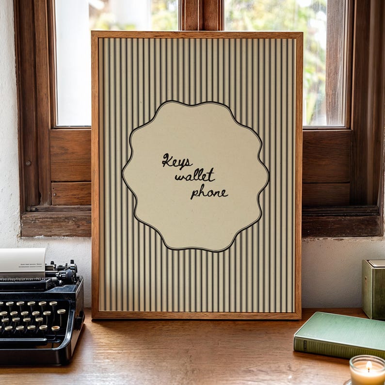 Hand drawn poster with the text "Keys wallet phone" inside a scalloped border on a neutral pinstripe background. Simple modern art used as Functional decor for Apartment decor or an Art for hall.