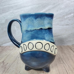 Ceramic moon phase cauldron mug with black glitter interior, handcrafted deep blue moon phase mug