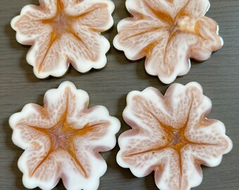 Puede incluir: Cuatro posavasos de resina blanca y marrón con diseño de flores. Los posavasos tienen un borde dorado.