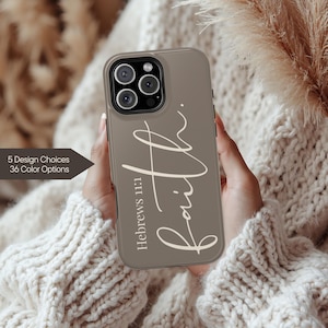 May include: A taupe phone case with the word "Faith" in a cursive font. The text "Hebrews 11:1" is below the word "Faith". The case is held in front of a cream-colored sweater. The text "5 Design Choices 36 Color Options" is on the left.