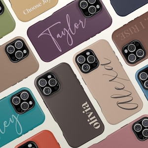 May include: A collection of smartphone cases in various solid matte colors including olive, plum, tan, brown, teal, and dusty rose. Several cases feature personalized names in script or block lettering, while others display phrases like Choose Joy and ALWAYS, I RISE.