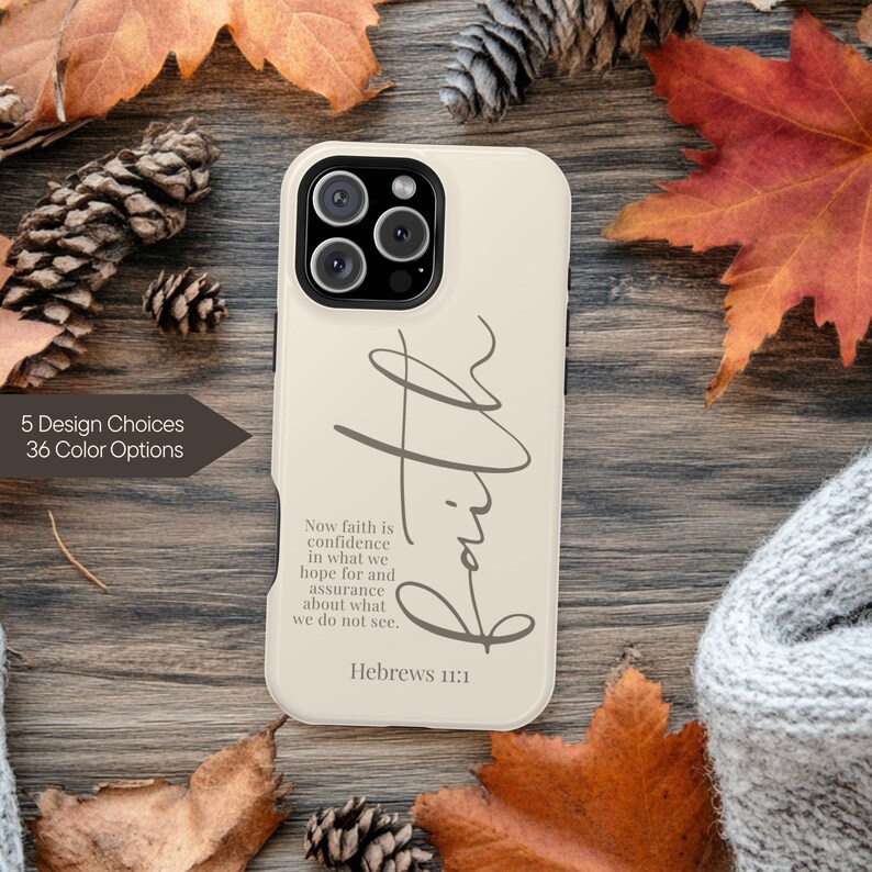 May include: A beige phone case with the word "Faith" in a cursive font. The case also features the text "Now faith is confidence in what we hope for and assurance about what we do not see. Hebrews 11:1." The image includes fall foliage.
