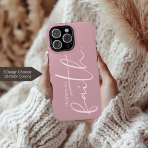 May include: A pink phone case with the word "Faith" in a cursive font. The text "Hebrews 11:1" is below the word "Faith". The case is held in a person's hands. The text "5 Design Choices 36 Color Options" is on the left.