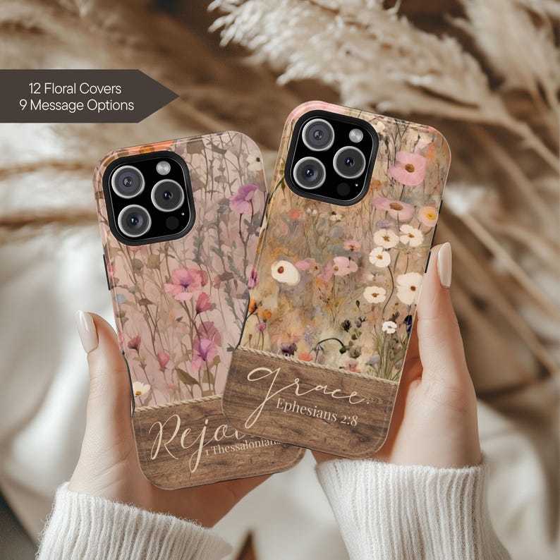 May include: Two floral phone cases with a wooden panel design. One case features the word "Rejoice" and the other says "Grace" with a Bible verse. The cases have a floral pattern in shades of pink, white, and brown.