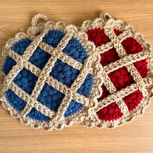 May include: Two handmade crochet pot holders in a pie crust design. One is blue, the other is red, with a tan lattice and scalloped edge. Each has a loop for hanging. Kitchen decor.