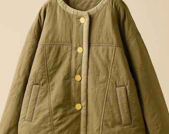 May include: Olive green jacket with a round collar and four gold buttons. The jacket has two front pockets and a light beige trim along the collar and button placket. The jacket is hanging on a beige rope hanger.
