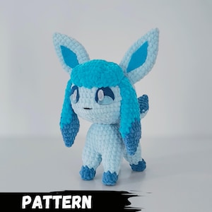 May include: A crocheted blue and light blue Eeveelution plush toy. The toy has a light blue body, blue ears, and a blue and light blue mane. The toy has a cute expression with white eyes.
