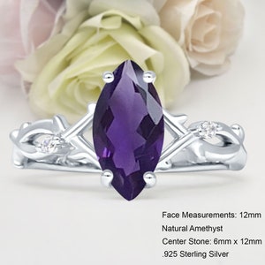 May include: A silver ring with a marquise-shaped amethyst gemstone and two smaller diamond accents. The ring has a delicate, vine-like design. Face Measurements: 12mm Natural Amethyst Center Stone: 6mm x 12mm .925 Sterling Silver