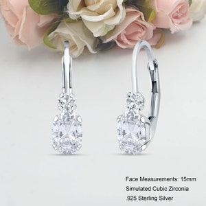Puede incluir: Pendientes de aro de plata con una piedra de circonita cúbica simulada de 15 mm y una piedra de acento más pequeña.  Medidas de la cara: 15 mm Circonita cúbica simulada Plata de ley 925