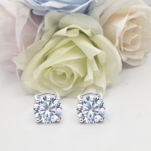 May include: A pair of silver stud earrings with clear round cubic zirconia stones.