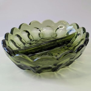 Peut inclure: Un plat de service divisé en deux parties, en verre vert avec un bord festonné. Le plat a un design texturé en relief.